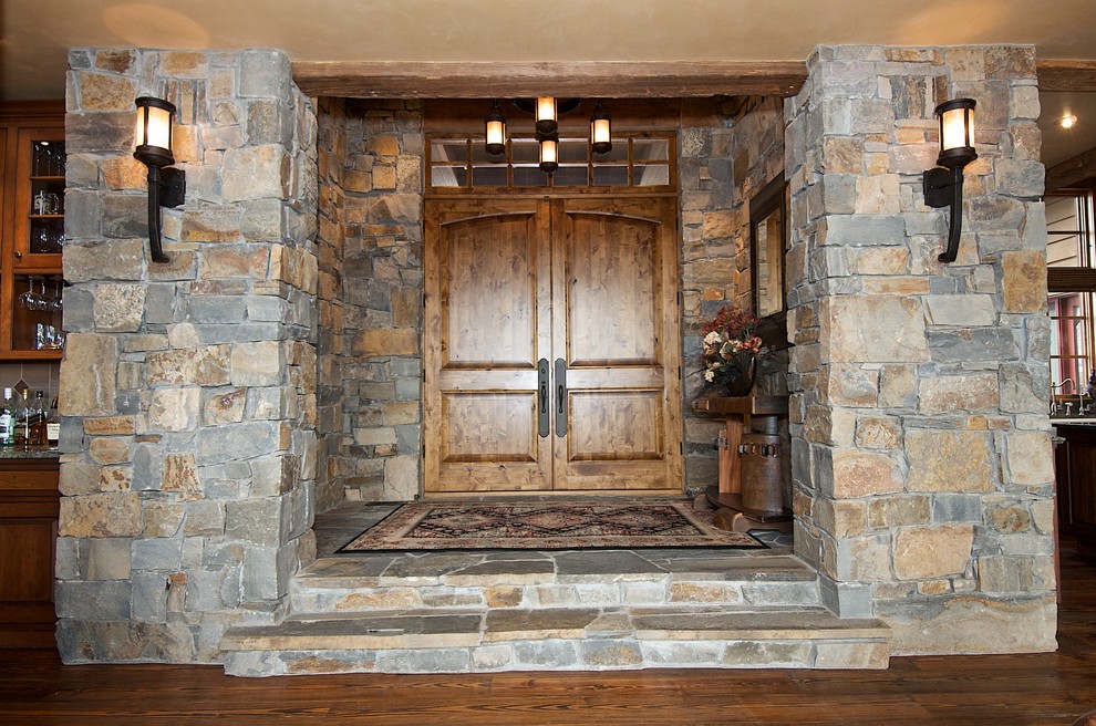 Large country foyer in Other with medium hardwood floors, a double front door, a dark wood front door and brown floor.