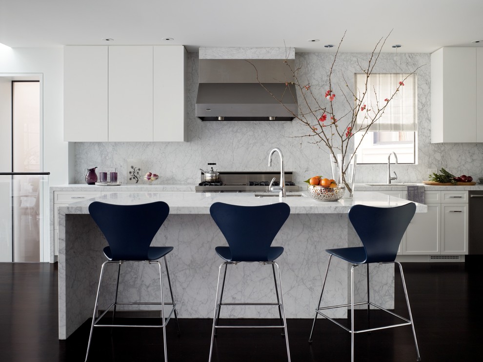 Inspiration for a contemporary kitchen in San Francisco with flat-panel cabinets, white cabinets, white splashback, stone slab splashback, stainless steel appliances, dark hardwood floors, with island and marble benchtops.
