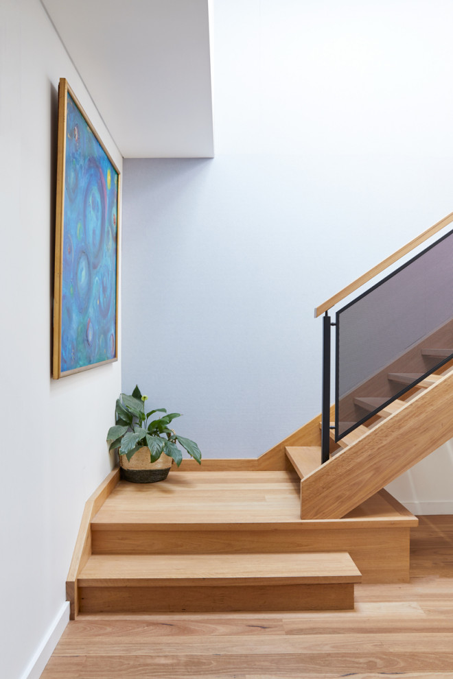 Foto de escalera en L contemporánea de tamaño medio sin contrahuella con escalones de madera y barandilla de madera