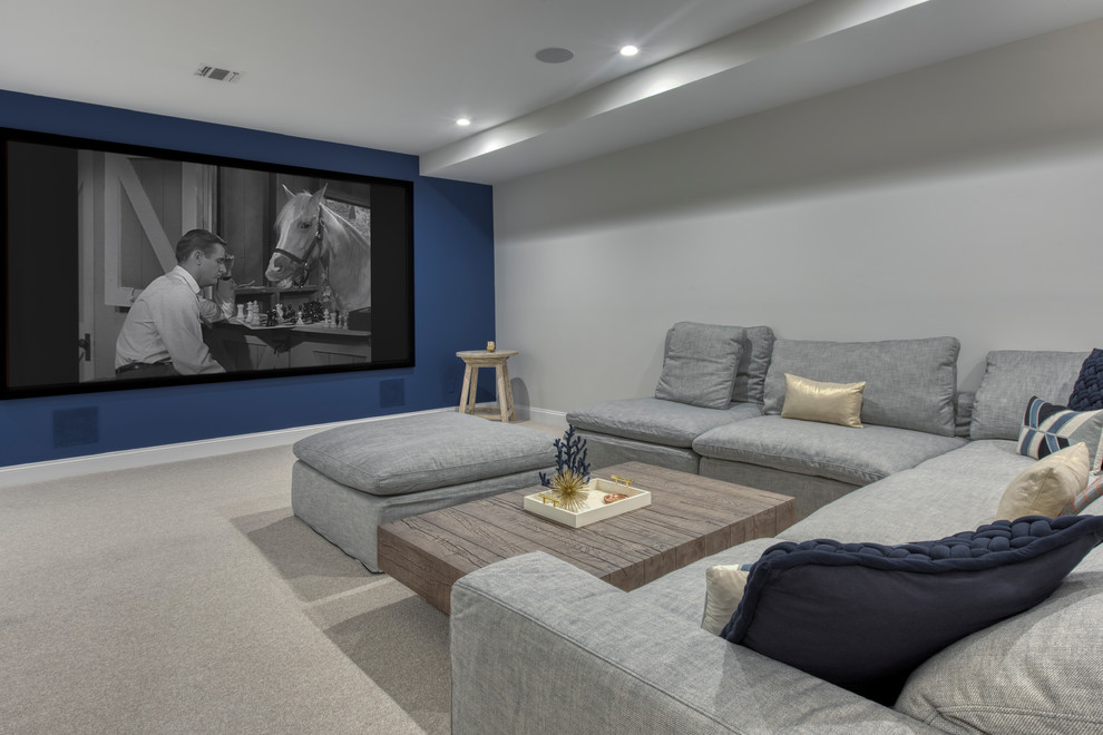 This is an example of a large modern open concept home theatre in New York with grey walls, carpet, a projector screen and grey floor.