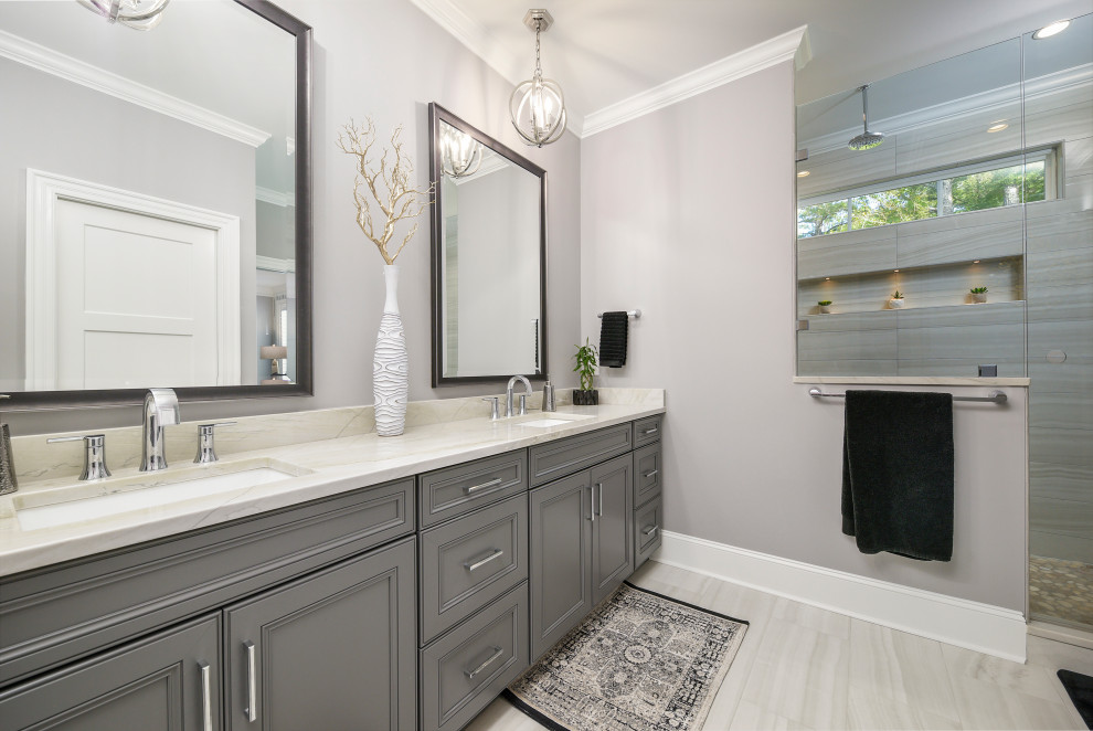 This is an example of a large transitional master bathroom in Other with grey cabinets, an alcove shower, gray tile, grey walls, light hardwood floors, an undermount sink, beige floor, a hinged shower door, beige benchtops and recessed-panel cabinets.