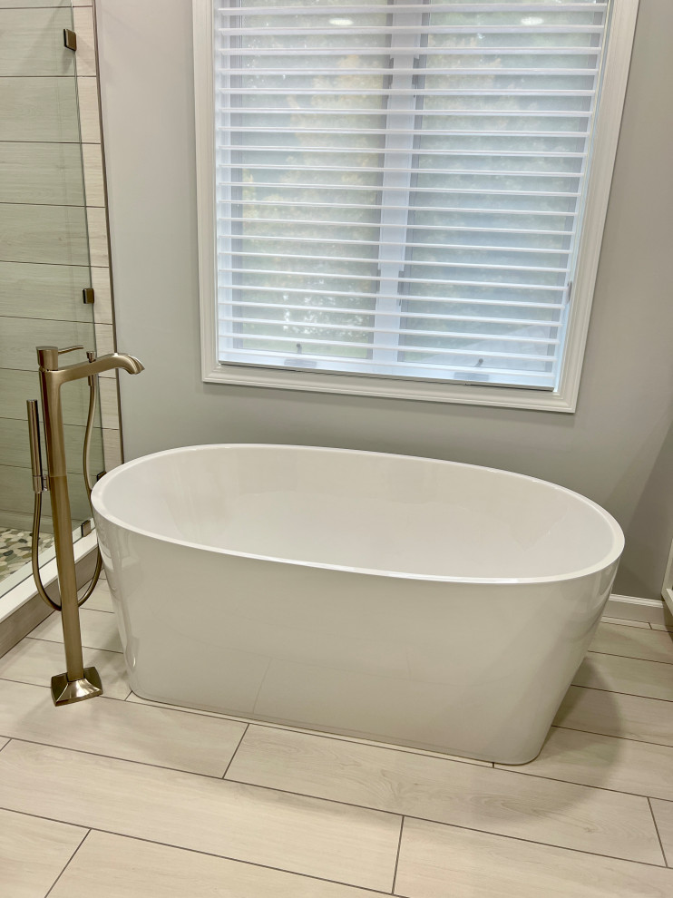 Foto de cuarto de baño principal actual grande con bañera exenta, paredes beige, suelo de baldosas de cerámica y suelo beige