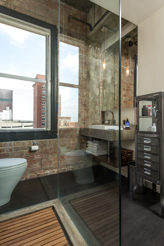 This is an example of an industrial bathroom in Houston with a one-piece toilet.