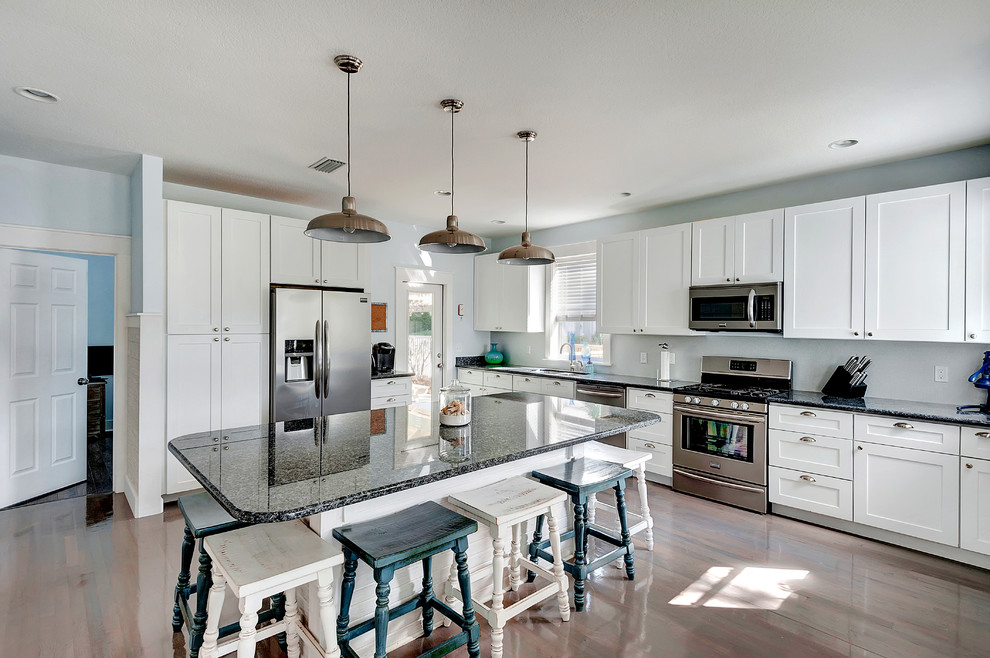Inspiration for a beach style l-shaped kitchen in Miami with shaker cabinets and white cabinets.