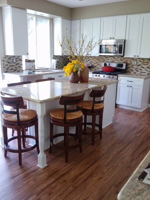 Inspiration for a mid-sized transitional l-shaped dark wood floor and brown floor eat-in kitchen remodel in Los Angeles with an undermount sink, shaker cabinets, white cabinets, granite countertops, multicolored backsplash, matchstick tile backsplash and an island