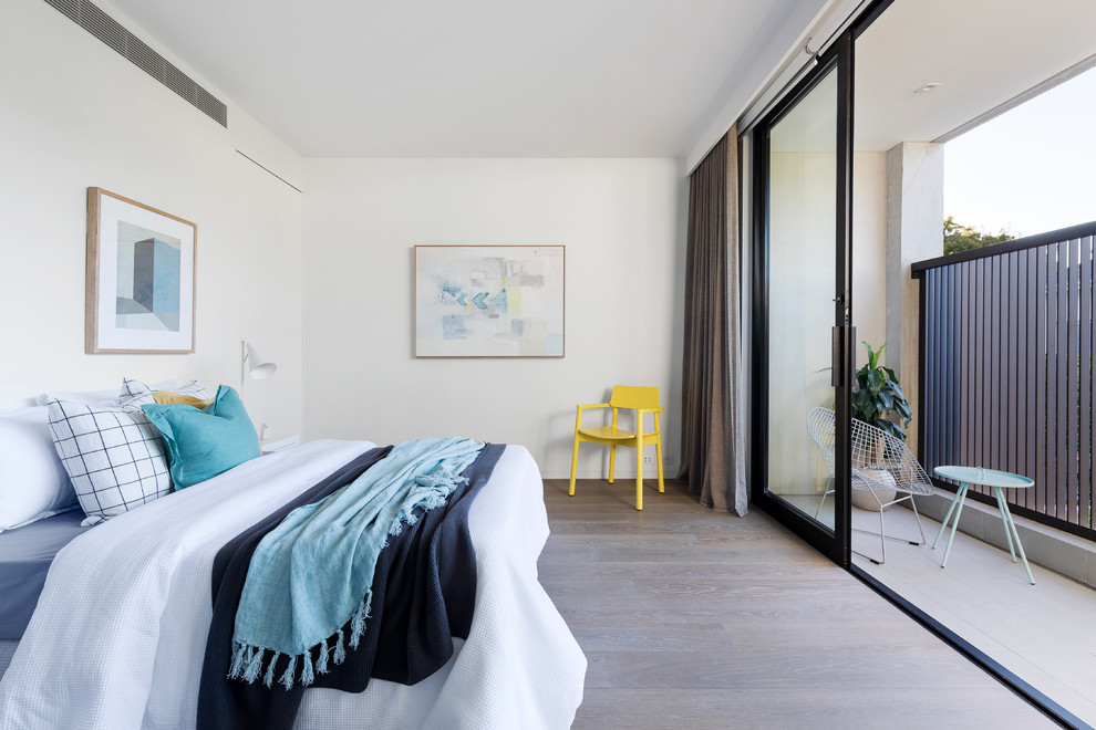 Photo of a contemporary master bedroom in Melbourne with white walls, medium hardwood floors and brown floor.