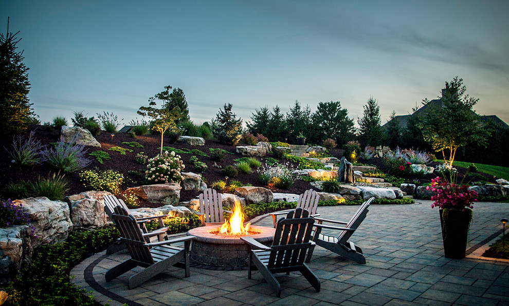 Photo of a large transitional backyard patio in Other with a fire feature and brick pavers.