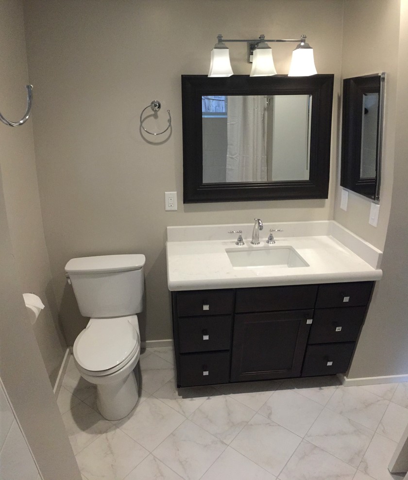 This is an example of a small transitional 3/4 bathroom in San Luis Obispo with an undermount sink, recessed-panel cabinets, dark wood cabinets, engineered quartz benchtops, an alcove tub, a shower/bathtub combo, a two-piece toilet, white tile, ceramic tile, beige walls and ceramic floors.