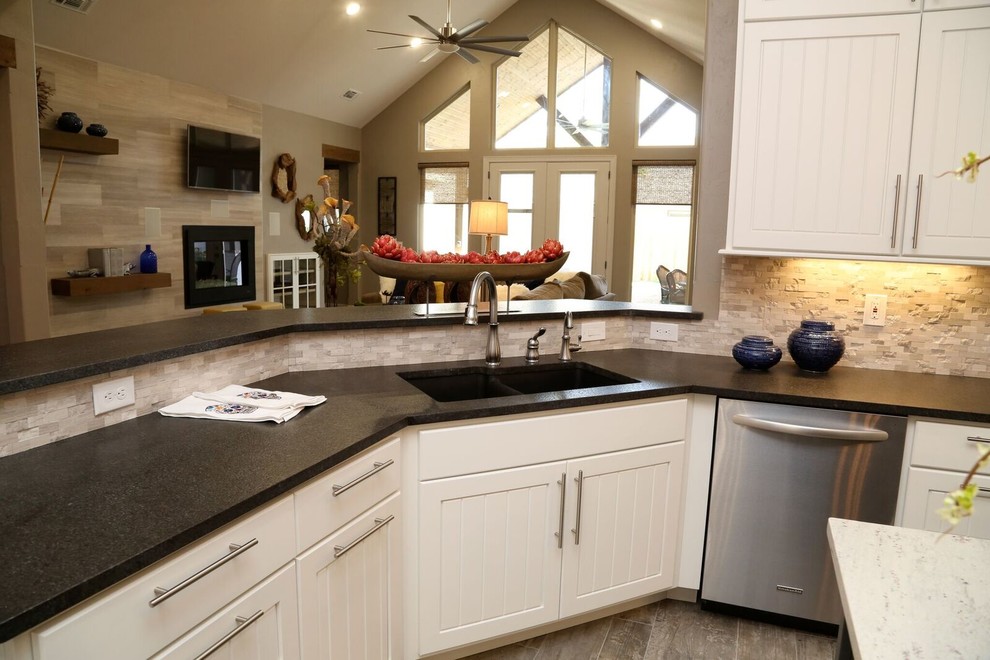 Open concept kitchen - small transitional u-shaped light wood floor open concept kitchen idea in Orange County with an undermount sink, louvered cabinets, white cabinets, solid surface countertops, beige backsplash, stone tile backsplash, stainless steel appliances and two islands