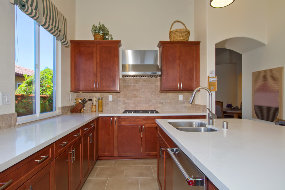 Large modern u-shaped eat-in kitchen in Los Angeles with a double-bowl sink, recessed-panel cabinets, brown cabinets, quartzite benchtops, beige splashback, stone tile splashback, stainless steel appliances, porcelain floors, with island, beige floor and white benchtop.