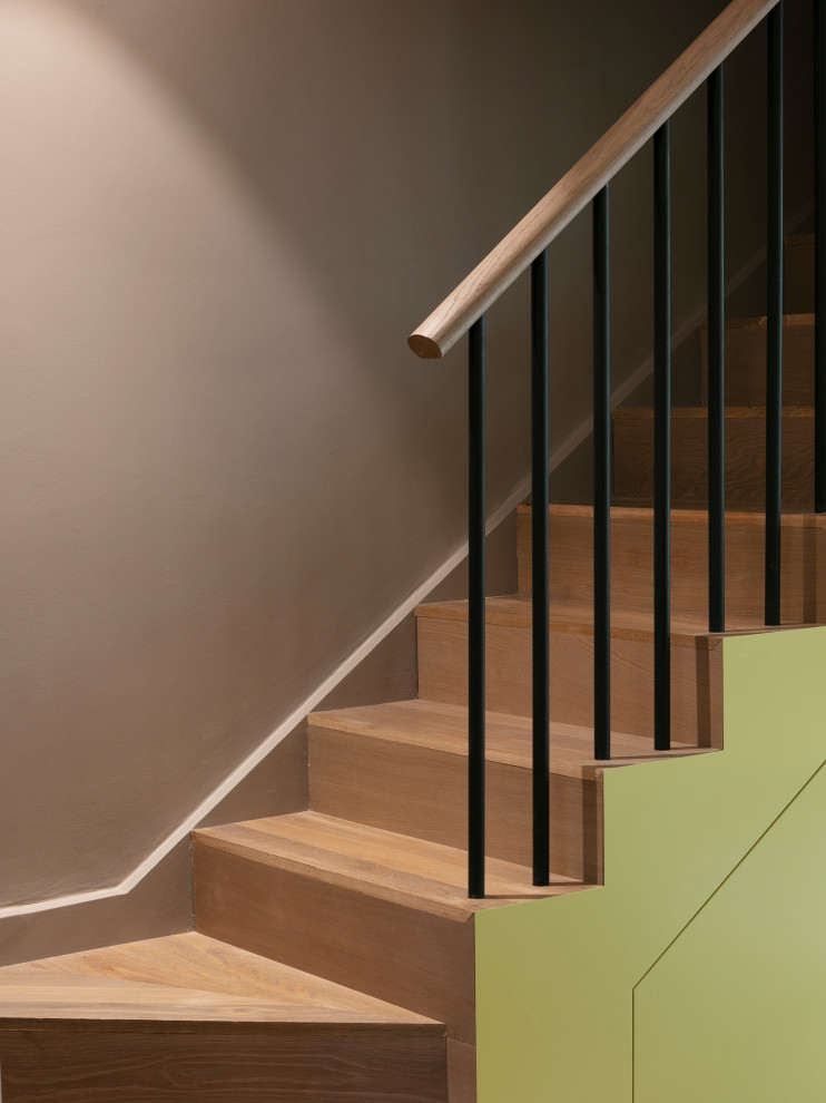 Inspiration for a medium sized contemporary wood u-shaped metal railing staircase spindle in London with wood risers.