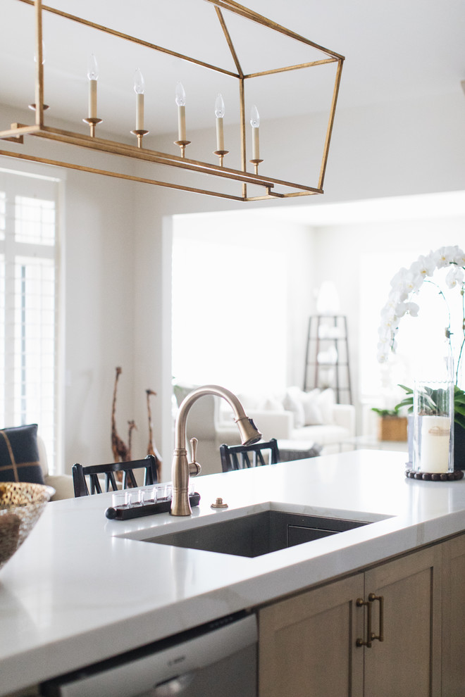 Inspiration for a large transitional u-shaped medium tone wood floor and brown floor kitchen remodel in Chicago with an undermount sink, shaker cabinets, beige cabinets, quartz countertops, glass tile backsplash, stainless steel appliances, an island and white countertops