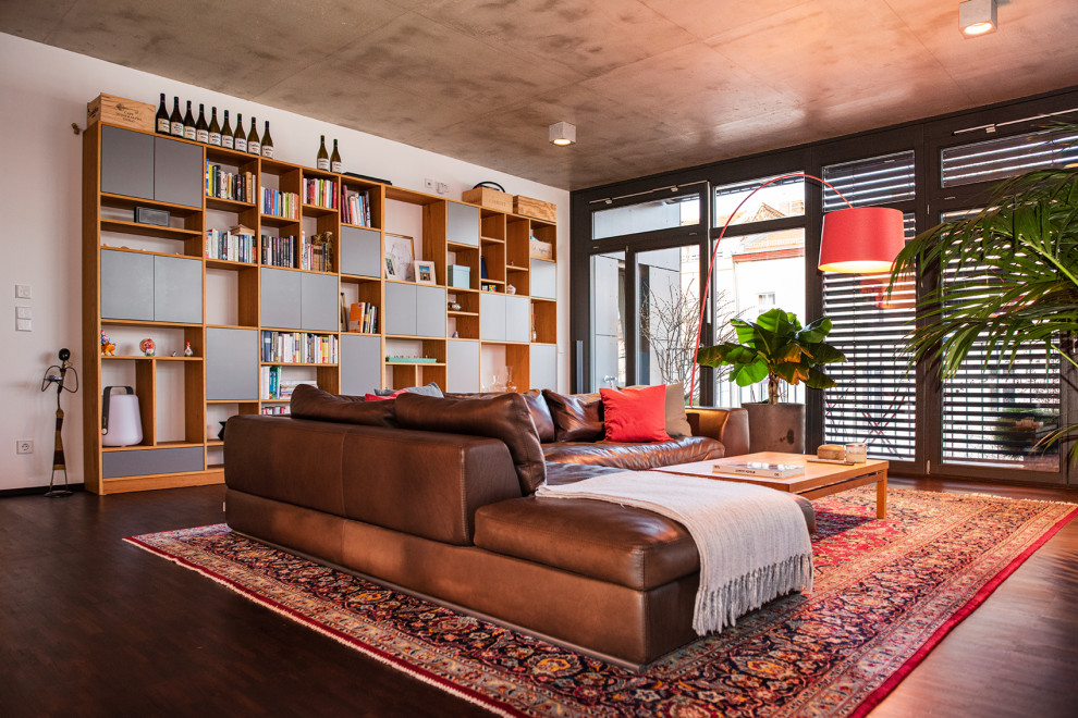 Großes, Offenes Modernes Wohnzimmer in grau-weiß ohne Kamin mit weißer Wandfarbe, dunklem Holzboden und braunem Boden in Berlin