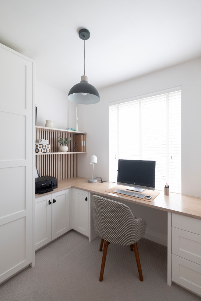 Kleines Mid-Century Arbeitszimmer mit Arbeitsplatz, weißer Wandfarbe, Teppichboden, Einbau-Schreibtisch und grauem Boden in Cardiff