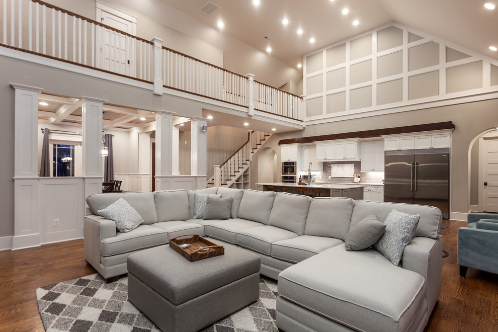 This is an example of a large transitional open concept living room in Charlotte with grey walls, medium hardwood floors and brown floor.