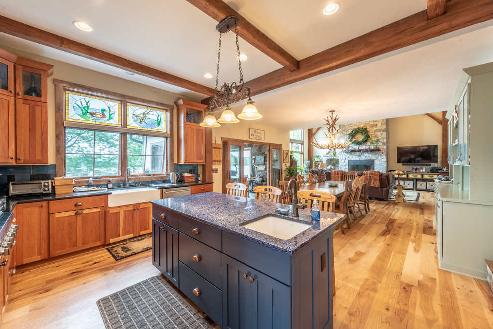 Mid-sized country kitchen/dining combo in Milwaukee with white walls, medium hardwood floors, a standard fireplace, a stone fireplace surround and yellow floor.