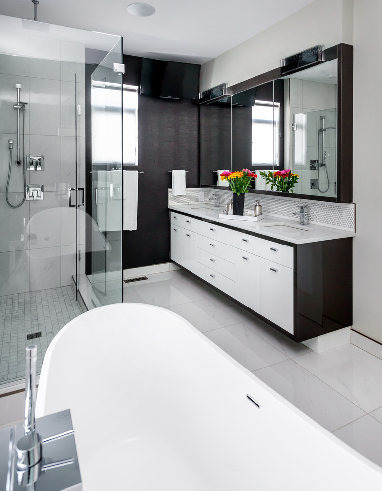 This is an example of a large contemporary master bathroom in Calgary with an undermount sink, flat-panel cabinets, white cabinets, engineered quartz benchtops, a freestanding tub, a corner shower, a one-piece toilet, white tile, porcelain tile, grey walls, porcelain floors, white floor and a hinged shower door.