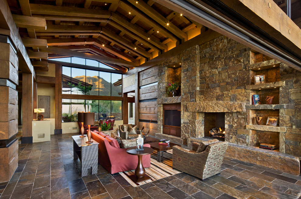 Design ideas for a country open concept living room in Phoenix with a standard fireplace, a stone fireplace surround, slate floors and a built-in media wall.