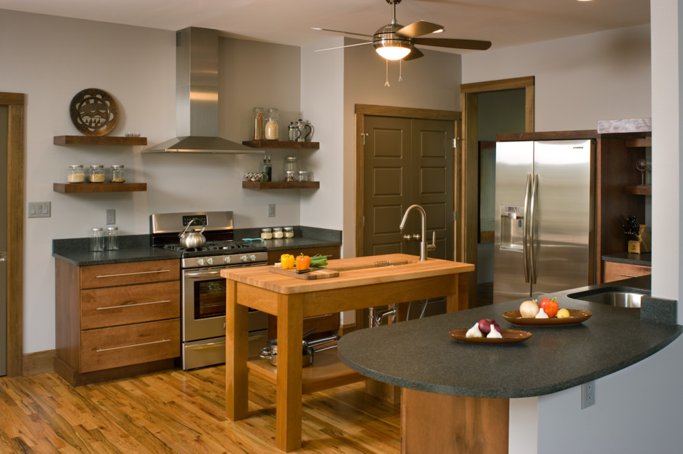 Inspiration for a mid-sized transitional l-shaped medium tone wood floor and brown floor kitchen remodel with an undermount sink, flat-panel cabinets, medium tone wood cabinets, stainless steel appliances and an island