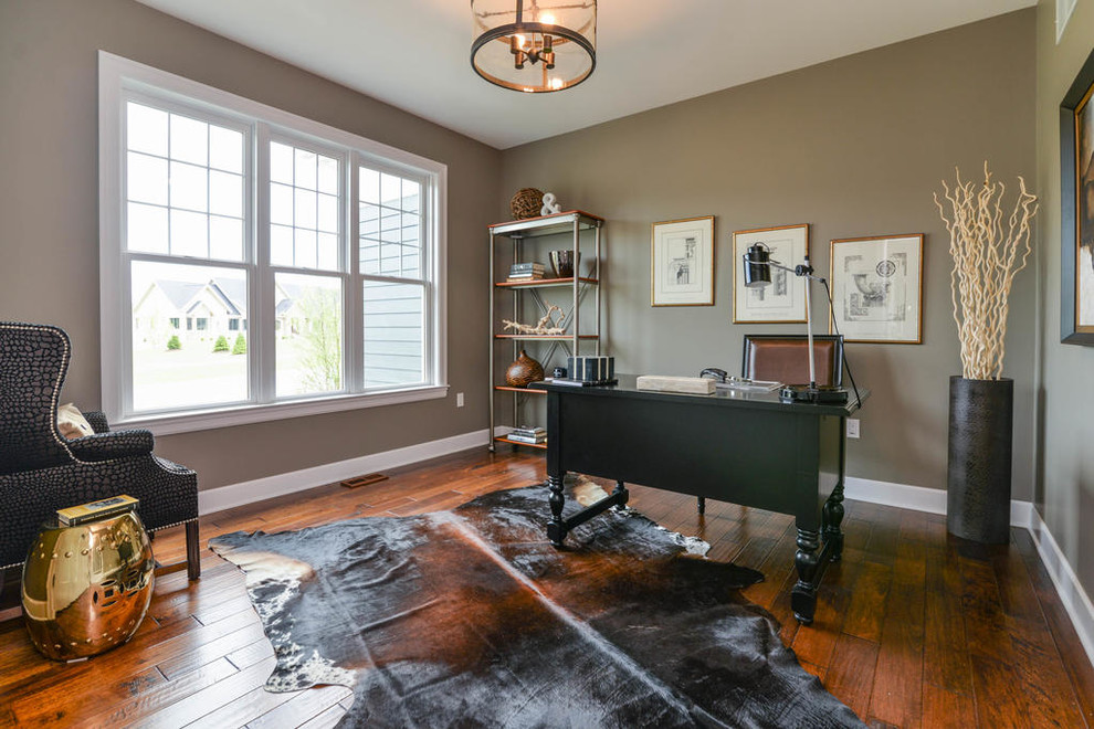 This is an example of a traditional study room in Detroit with beige walls, dark hardwood floors and a freestanding desk.