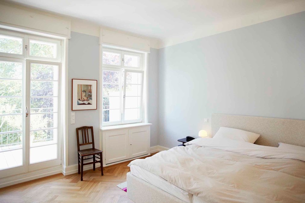 Photo of a mid-sized traditional master bedroom in Frankfurt with blue walls, medium hardwood floors and no fireplace.
