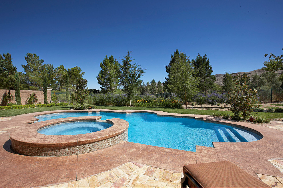 Inspiration for a traditional backyard custom-shaped pool in Orange County with stamped concrete.