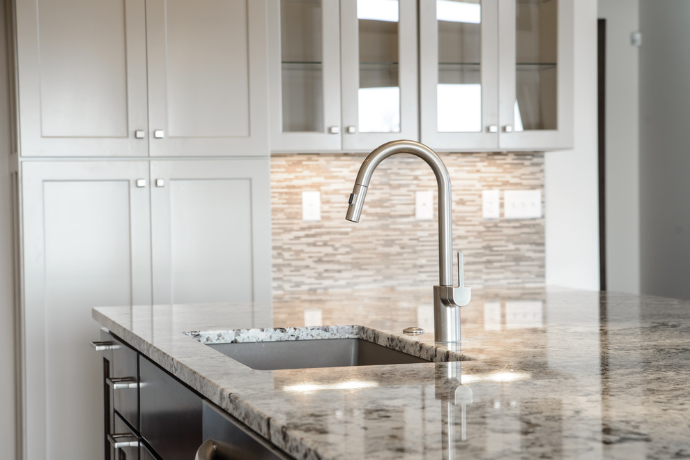 Open concept kitchen - transitional l-shaped medium tone wood floor open concept kitchen idea with a farmhouse sink, shaker cabinets, white cabinets, stainless steel appliances and an island