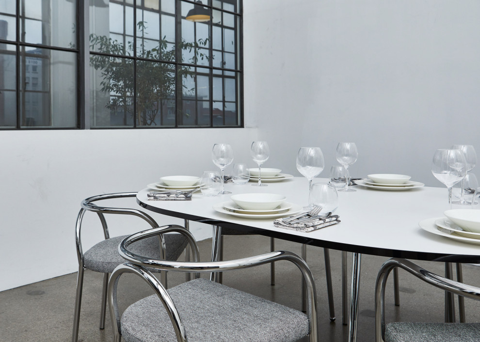 Bild på en minimalistisk matplats, med vita väggar, betonggolv och grått golv