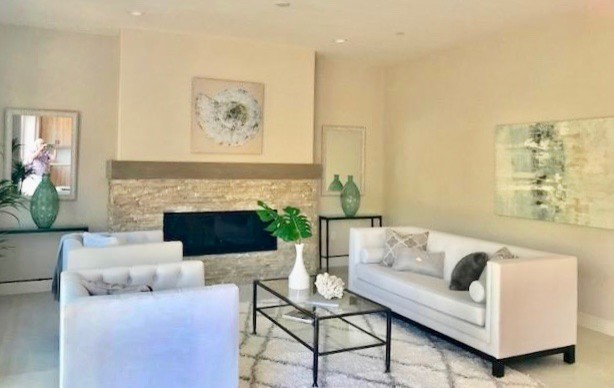 Inspiration for a large modern formal open concept living room in San Diego with white walls, porcelain floors, a standard fireplace, a stone fireplace surround, a wall-mounted tv and grey floor.