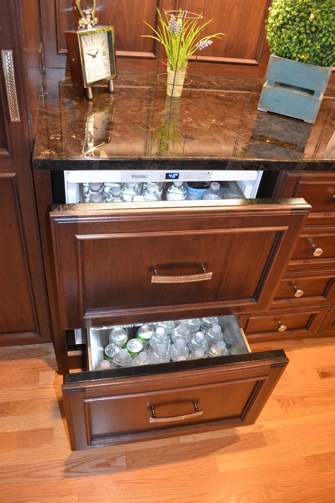 Large transitional u-shaped medium tone wood floor eat-in kitchen photo in Boston with an undermount sink, raised-panel cabinets, white cabinets, granite countertops, white backsplash, ceramic backsplash, stainless steel appliances and white walls