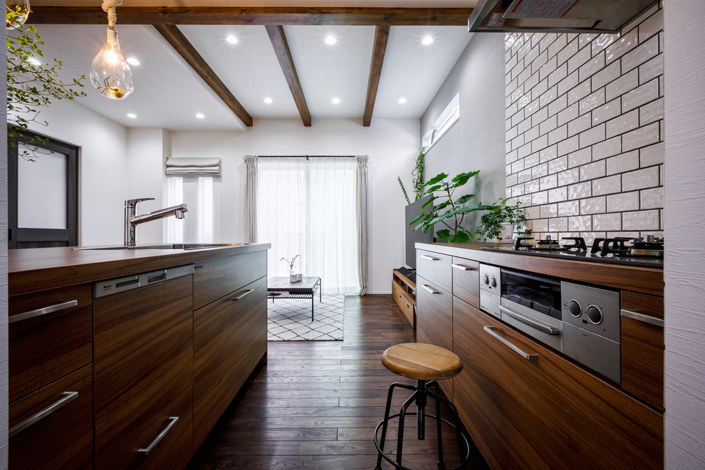 Design ideas for a midcentury galley open plan kitchen in Tokyo with an undermount sink, beaded inset cabinets, medium wood cabinets, white splashback, subway tile splashback, stainless steel appliances, dark hardwood floors, a peninsula, brown floor and brown benchtop.