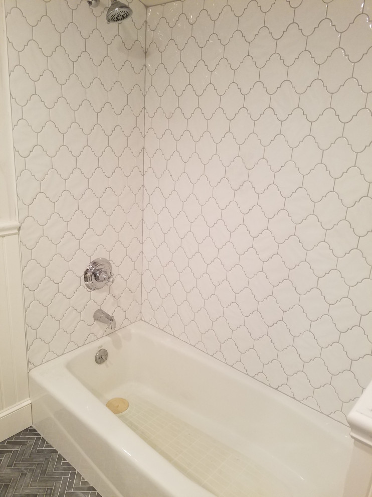Design ideas for a mid-sized modern 3/4 bathroom in New York with recessed-panel cabinets, white cabinets, an alcove tub, a two-piece toilet, white tile, marble, marble floors, an undermount sink, multi-coloured benchtops, a single vanity, a freestanding vanity, vaulted and a shower/bathtub combo.