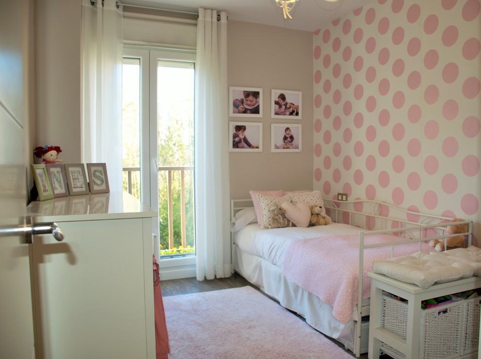 Photo of a mid-sized transitional kids' bedroom for kids 4-10 years old and girls in Other with pink walls and medium hardwood floors.
