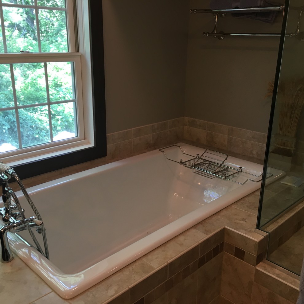 Photo of a small arts and crafts master bathroom in New York with a drop-in tub, an alcove shower, beige tile, ceramic tile, beige walls, ceramic floors, beige floor and a hinged shower door.