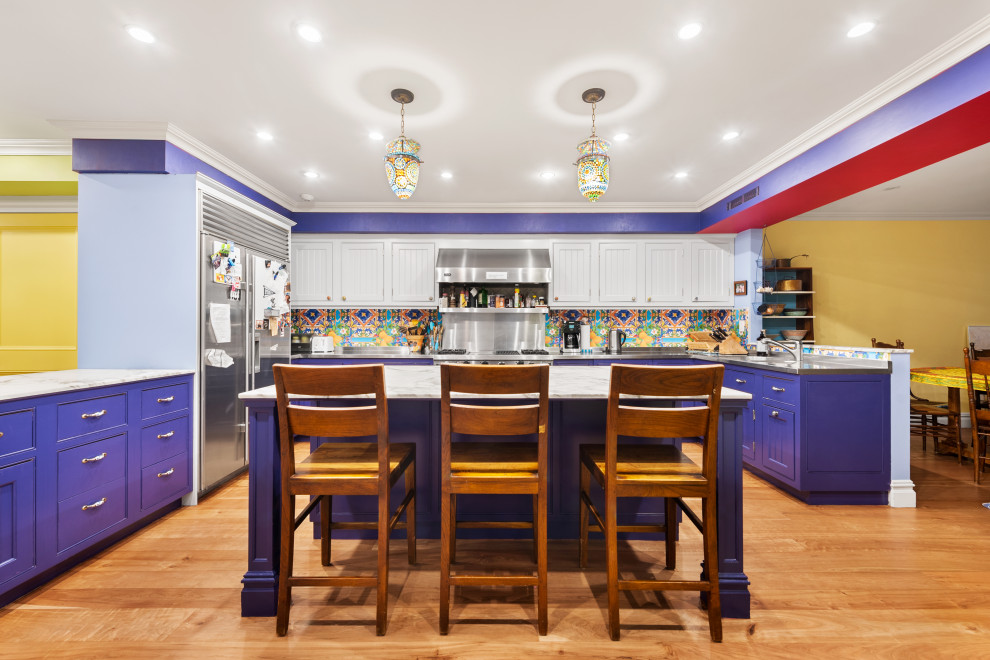 Large eclectic u-shaped eat-in kitchen in New York with a drop-in sink, shaker cabinets, purple cabinets, marble benchtops, multi-coloured splashback, ceramic splashback, stainless steel appliances, light hardwood floors, with island, beige floor and grey benchtop.