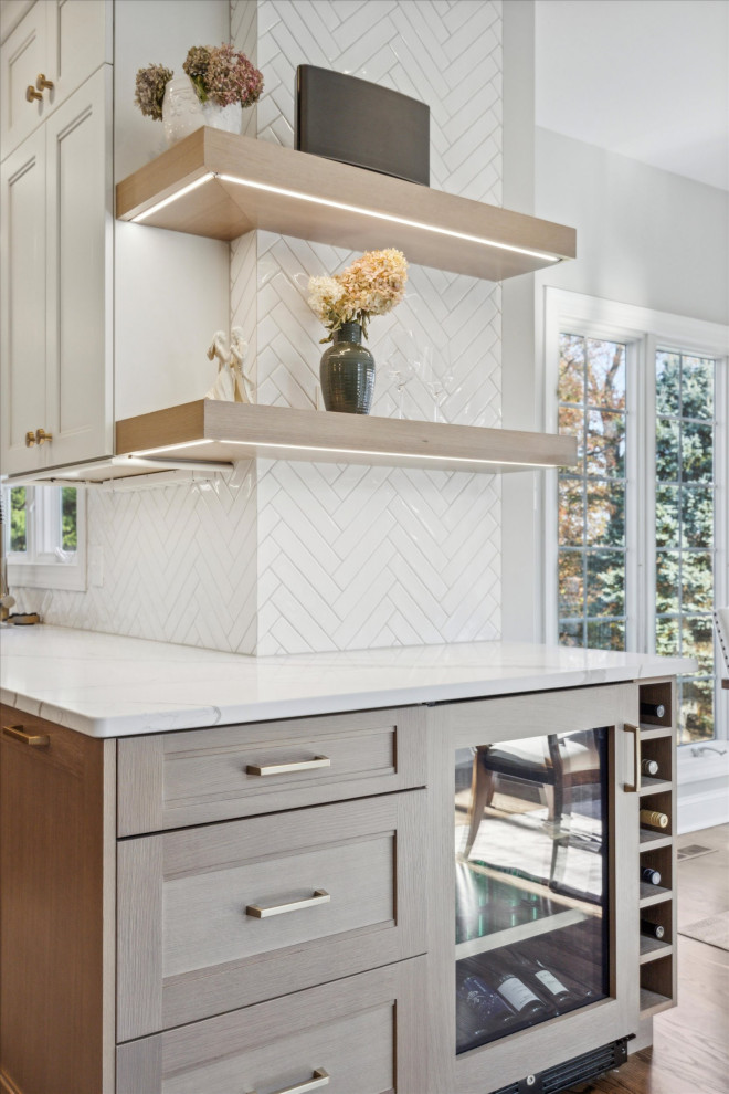 Example of a large transitional medium tone wood floor and brown floor eat-in kitchen design in Philadelphia with an undermount sink, shaker cabinets, light wood cabinets, quartz countertops, white backsplash, ceramic backsplash, paneled appliances, an island and white countertops