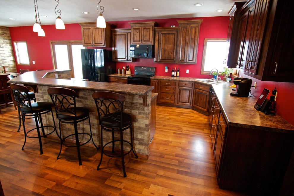 Large open concept kitchen photo with raised-panel cabinets, dark wood cabinets, laminate countertops and an island