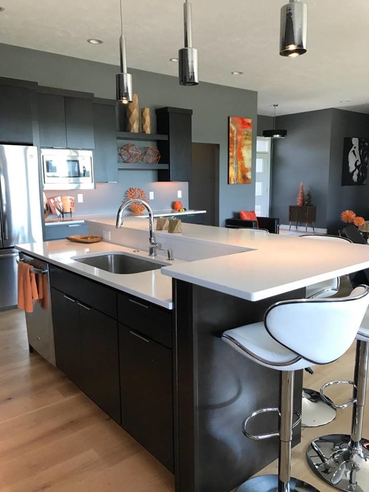 Example of a small trendy kitchen design with an undermount sink, flat-panel cabinets, dark wood cabinets, stainless steel appliances and an island