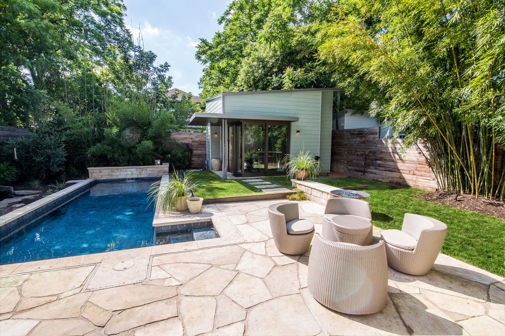 This is an example of a mid-sized modern backyard patio in Austin with natural stone pavers.