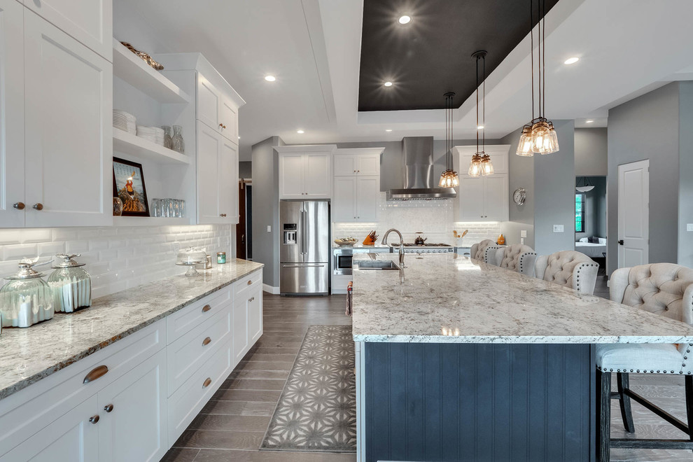 Design ideas for a country eat-in kitchen in Denver with an undermount sink, white cabinets, quartzite benchtops, white splashback, subway tile splashback, stainless steel appliances, light hardwood floors, with island, multi-coloured floor and multi-coloured benchtop.