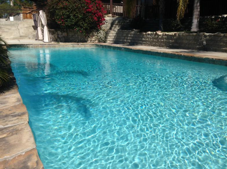Example of a huge mountain style backyard stone and rectangular lap pool design in Los Angeles