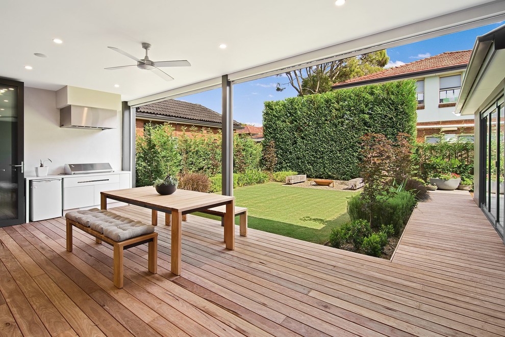 Photo of a contemporary backyard deck in Melbourne with an outdoor kitchen and a roof extension.