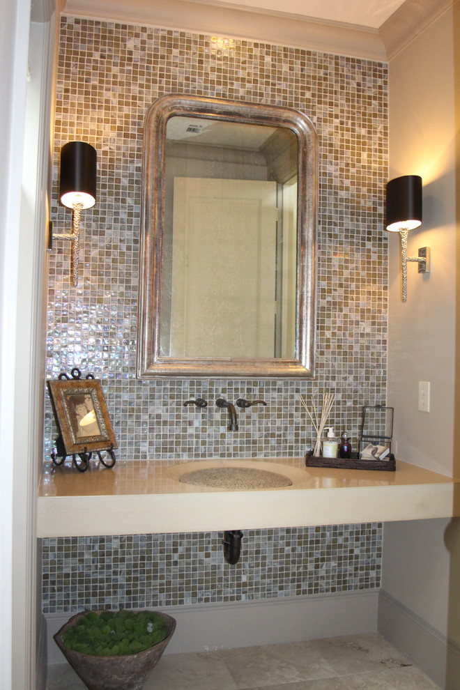 This is an example of a mid-sized eclectic powder room in Austin with multi-coloured tile, beige walls, travertine floors, an integrated sink and mosaic tile.