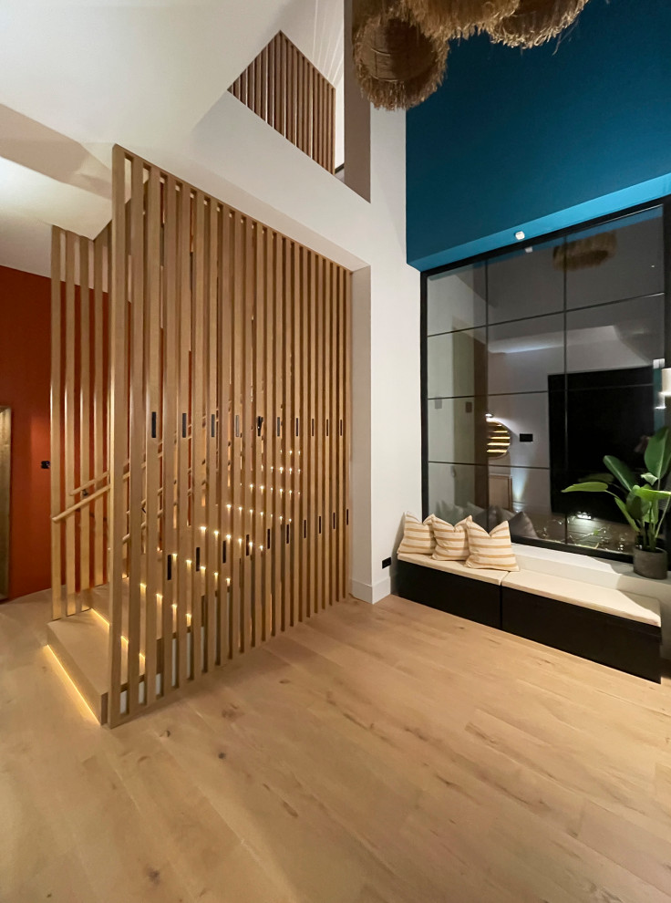 Imagen de recibidores y pasillos tropicales de tamaño medio con paredes azules, suelo de madera en tonos medios, suelo marrón y boiserie