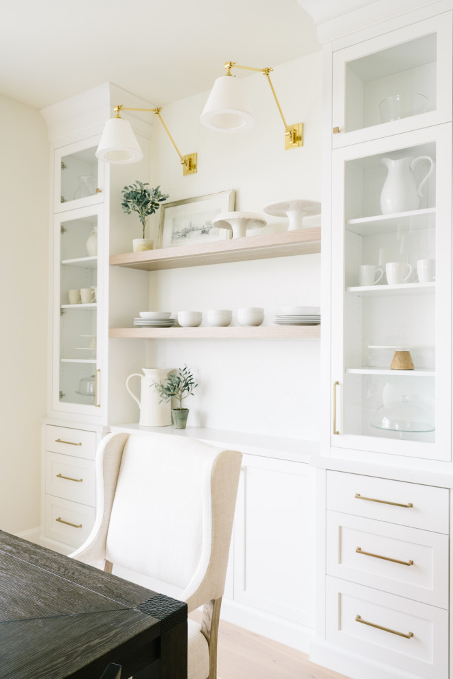 This is an example of a transitional eat-in kitchen in Salt Lake City with a farmhouse sink, shaker cabinets, white cabinets, white splashback, panelled appliances, light hardwood floors, multiple islands and white benchtop.