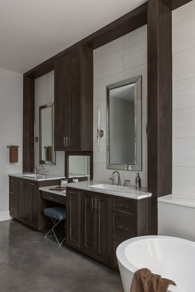 Photo of a contemporary ensuite bathroom in Austin with recessed-panel cabinets, dark wood cabinets, a freestanding bath, a built-in shower, grey tiles, porcelain tiles, concrete flooring, a submerged sink, marble worktops, brown worktops, a wall niche, double sinks and a built in vanity unit.