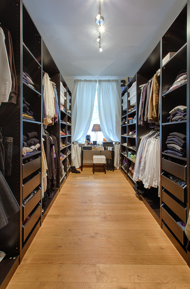 Design ideas for a mid-sized contemporary gender-neutral walk-in wardrobe in Munich with open cabinets and black cabinets.