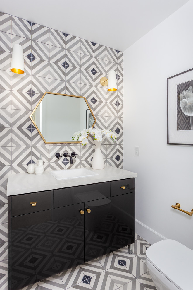 Inspiration for a mid-sized modern powder room in Orange County with flat-panel cabinets, gray tile, cement tile, white walls, a drop-in sink, engineered quartz benchtops, cement tiles and black cabinets.