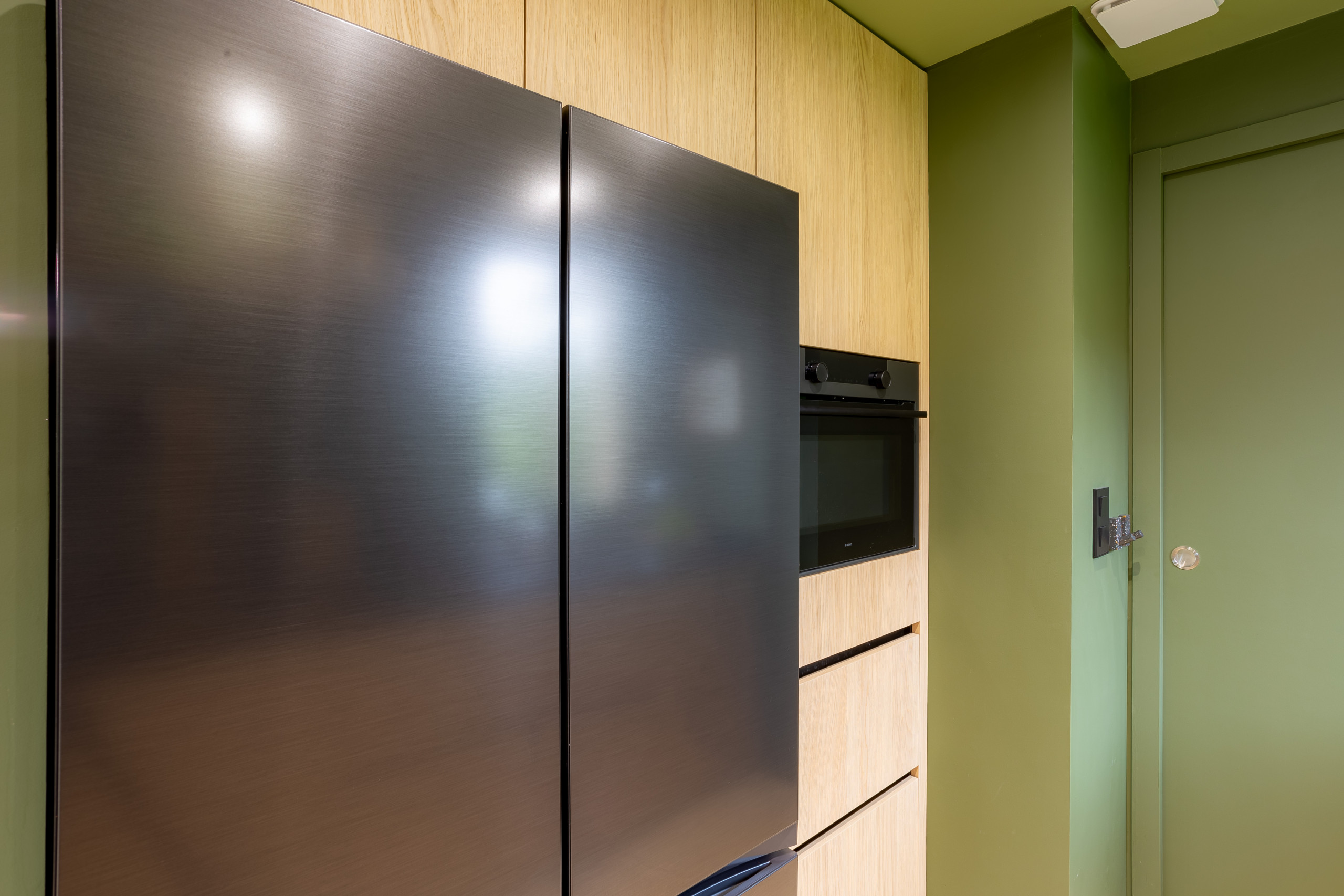 Réalisation d'une cuisine noire et bois dans un écrin végétal