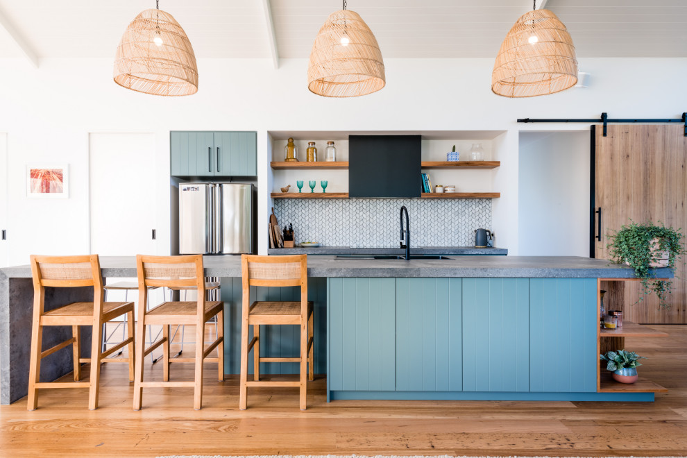 Contemporary galley kitchen in Geelong with a built-in sink, flat-panel cabinets, blue cabinets, white splashback, mosaic tiled splashback, medium hardwood flooring, an island, brown floors, grey worktops, a timber clad ceiling and a vaulted ceiling.